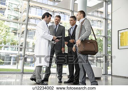 Stock Image - Doctor and businessmen talking. Fotosearch