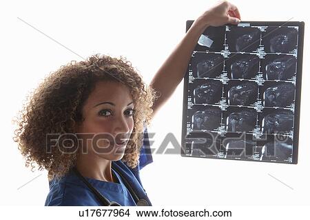 Doctor examining sheet of x-rays View Large Photo Image Picture - Doctor examining sheet of x-rays. Fotosearch
