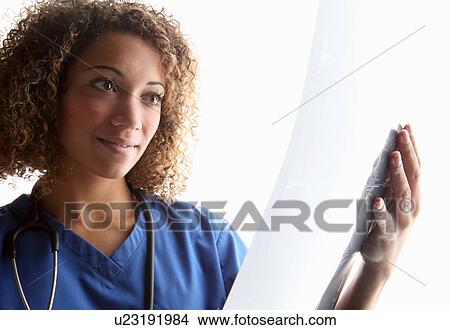 Doctor examining sheet of x-rays View Large Photo Image Picture - Doctor examining sheet of x-rays. Fotosearch