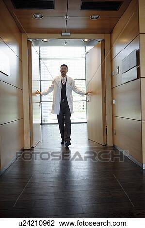 Doctor walking in office hallway View Large Photo Image Stock Image - Doctor walking in office hallway. Fotosearch