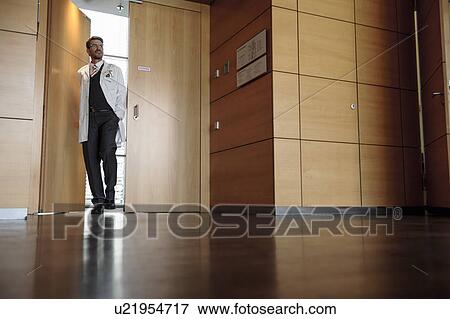 Doctor walking in office hallway View Large Photo Image Stock Photo - Doctor walking in office hallway. Fotosearch