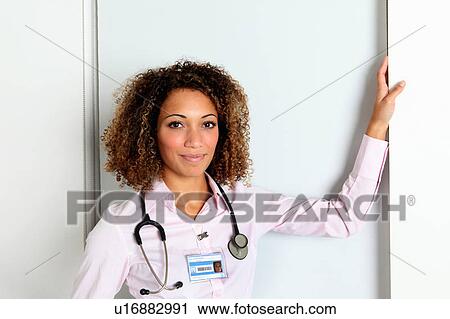 Stock Image - Doctor wearing stethoscope in hospital. Fotosearch