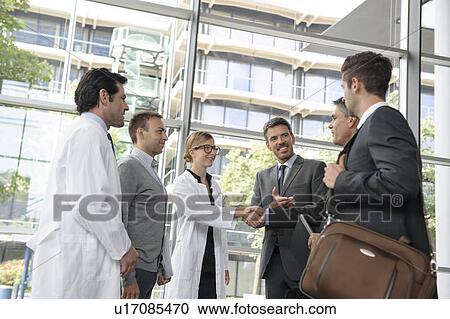 Stock Image - Doctors and businessmen meeting. Fotosearch
