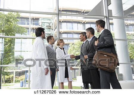 Stock Photograph - Doctors and businessmen meeting. Fotosearch