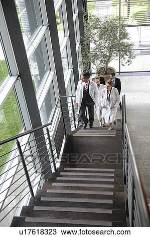 Doctors climbing staircase in office View Large Photo Image Stock Image - Doctors climbing staircase in office. Fotosearch