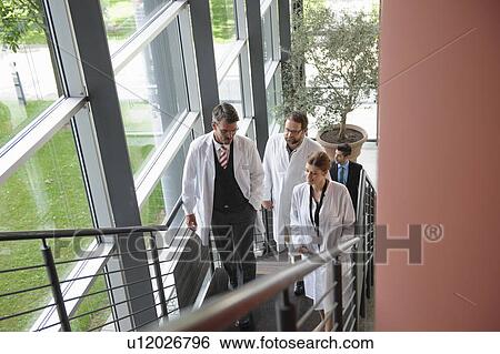 Stock Photograph - Doctors climbing staircase in office. Fotosearch