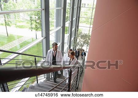 Stock Photograph - Doctors climbing staircase in office. Fotosearch