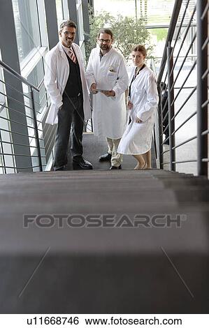 Stock Photograph - Doctors talking on staircase in office. Fotosearch