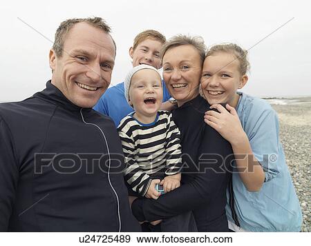 Family laughing together on rocky beach View Large Photo Image Stock Photo - Family laughing together on rocky beach. Fotosearch