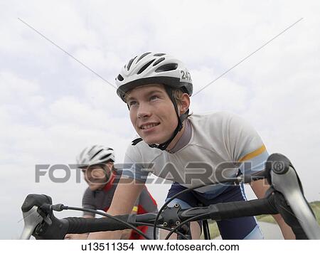 Picture - Father and son cycling on rural road. Fotosearch