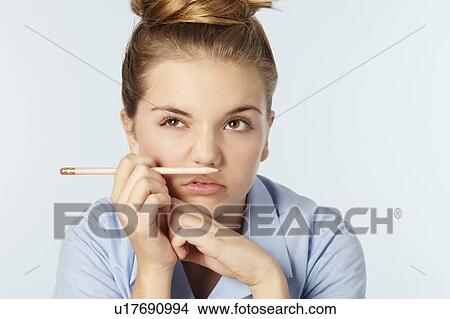 Picture - Frustrated girl holding chin in hands. Fotosearch