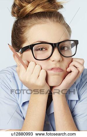 Stock Image - Frustrated girl holding chin in hands. Fotosearch