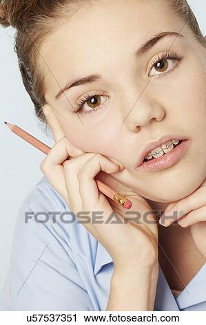 Stock Image - Frustrated girl holding chin in hands. Fotosearch