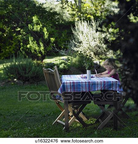 Girl drawing at table outdoors View Large Photo Image Stock Photograph - Girl drawing at table outdoors. Fotosearch