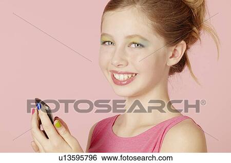 Girl in colorful makeup using cell phone View Large Photo Image Stock Photograph - Girl in colorful makeup using cell phone. Fotosearch