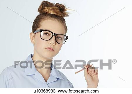 Stock Image - Girl in glasses holding pencil in hand. Fotosearch