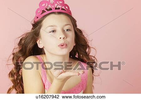 Stock Image - Girl in pink tiara blowing kisses. Fotosearch