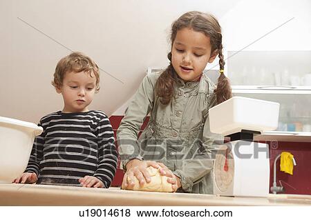Stock Photo - Girl kneading dough in kitchen. Fotosearch