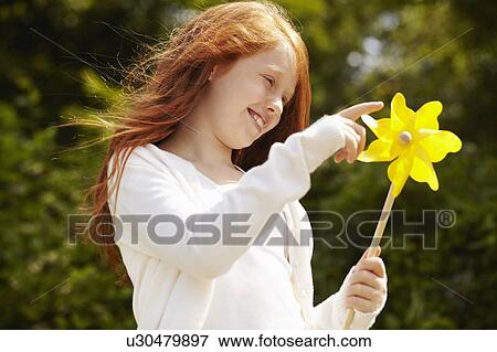 Girl playing with pinwheel outdoors View Large Photo Image Stock Photo - Girl playing with pinwheel outdoors. Fotosearch
