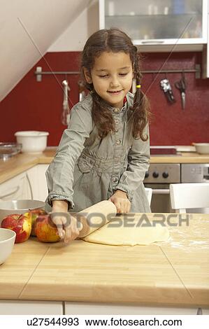 Girl rolling pastry dough in kitchen View Large Photo Image Stock Image - Girl rolling pastry dough in kitchen. Fotosearch