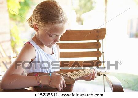 Girl strumming ukulele outdoors View Large Photo Image Stock Image - Girl strumming ukulele outdoors. Fotosearch