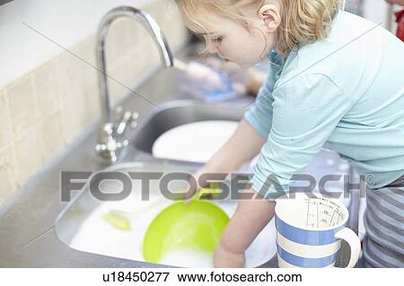 Girl washing dishes in kitchen View Large Photo Image Stock Photo - Girl washing dishes in kitchen. Fotosearch