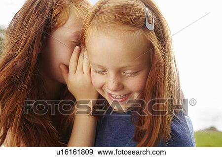 Girls whispering to each other outdoors View Large Photo Image Stock Photo - Girls whispering to each other outdoors. Fotosearch