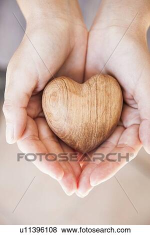 Stock Photo - Hands holding carved wood heart. Fotosearch