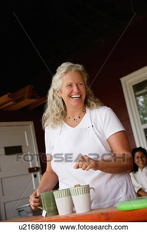 Stock Photo - Laughing woman making cups of tea. Fotosearch