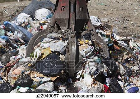 Machinery grabbing waste in landfill View Large Photo Image Stock Photo - Machinery grabbing waste in landfill. Fotosearch