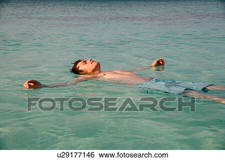 Stock Photograph - Man floating in tropical water. Fotosearch