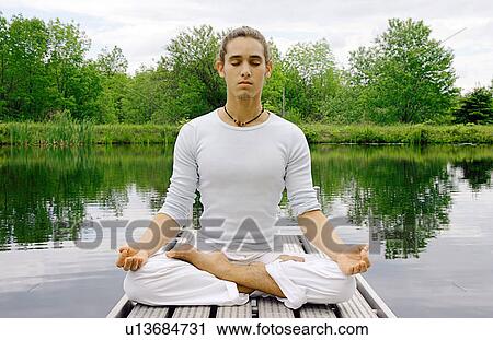 Man meditating on wooden pier View Large Photo Image Stock Image - Man meditating on wooden pier. Fotosearch