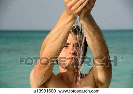 Stock Image - Man playing in tropical water. Fotosearch