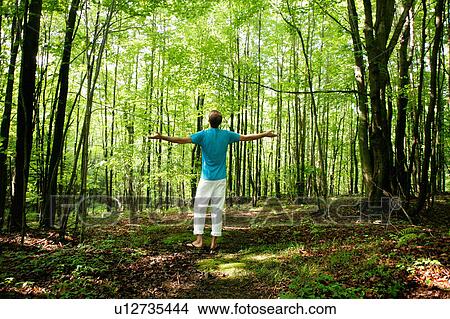 Man standing in forest View Large Photo Image Picture - Man standing in forest. Fotosearch