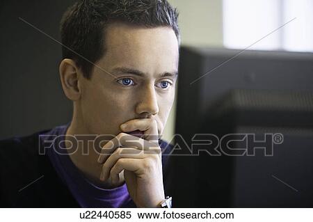 Stock Photography - Man using computer at desk. Fotosearch
