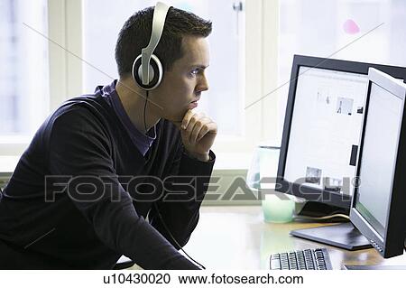 Man using computers at desk View Large Photo Image Stock Image - Man using computers at desk. Fotosearch
