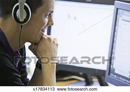 Man using computers at desk View Large Photo Image Stock Image - Man using computers at desk. Fotosearch