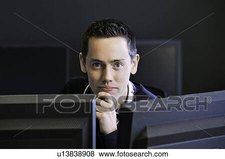 Man using computers at desk View Large Photo Image Stock Photo - Man using computers at desk. Fotosearch