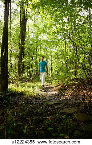 Stock Photography - Man walking in forest. Fotosearch