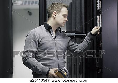 Man working in server room View Large Photo Image Stock Photo - Man working in server room. Fotosearch