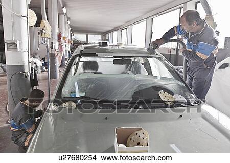 Picture - Mechanics working on car in garage. Fotosearch