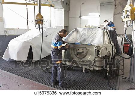 Mechanics working on car in garage View Large Photo Image Stock Photograph - Mechanics working on car in garage. Fotosearch
