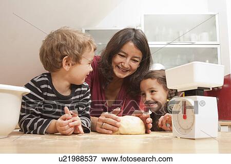 Mother and children baking in kitchen View Large Photo Image Stock Photo - Mother and children baking in kitchen. Fotosearch