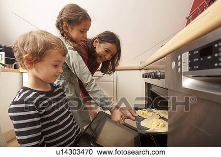 Stock Image - Mother and children baking together. Fotosearch