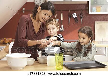 Mother and children cooking in kitchen View Large Photo Image Stock Photo - Mother and children cooking in kitchen. Fotosearch