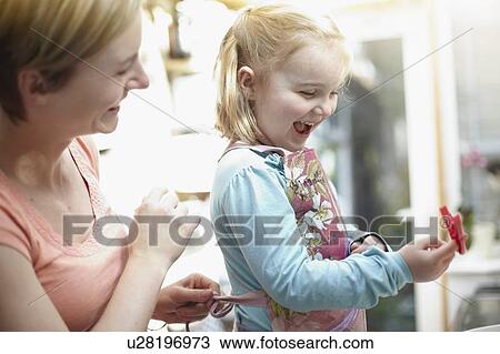 Stock Image - Mother and daughter baking together. Fotosearch