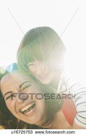 Stock Image - Mother and daughter hugging outdoors. Fotosearch