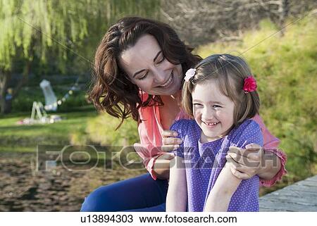 Mother and daughter sitting outdoors View Large Photo Image Stock Image - Mother and daughter sitting outdoors. Fotosearch