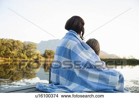 Picture - Mother and daughter wrapped in blanket. Fotosearch