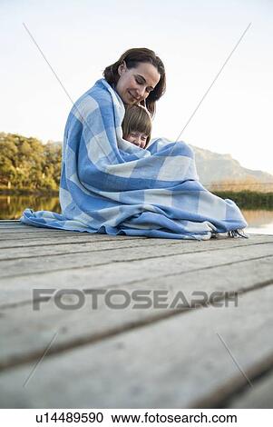 Stock Image - Mother and daughter wrapped in blanket. Fotosearch